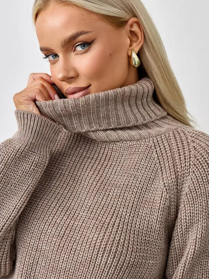 Close-up of a woman in the Siena Sweater from Lauven, showcasing its oversized beige knit and turtleneck design.