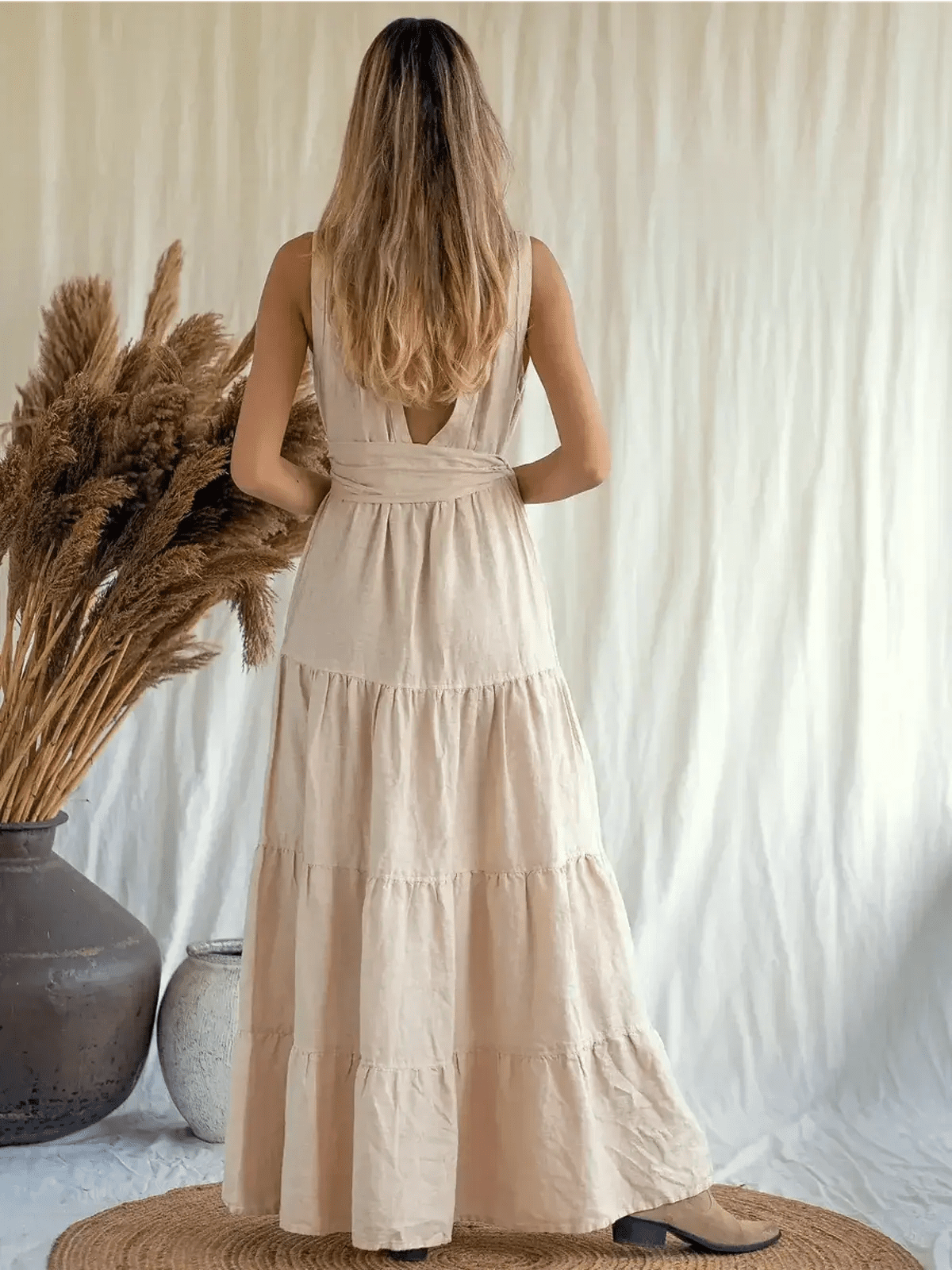 Back view of a woman wearing a Sierra Maxi Dress in breathable linen, showcasing a tiered A-line silhouette.