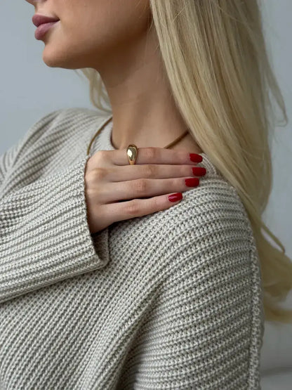 Model wearing the Sierra Sweater by Lauven, showcasing a stylish oversized beige knit and statement jewelry.