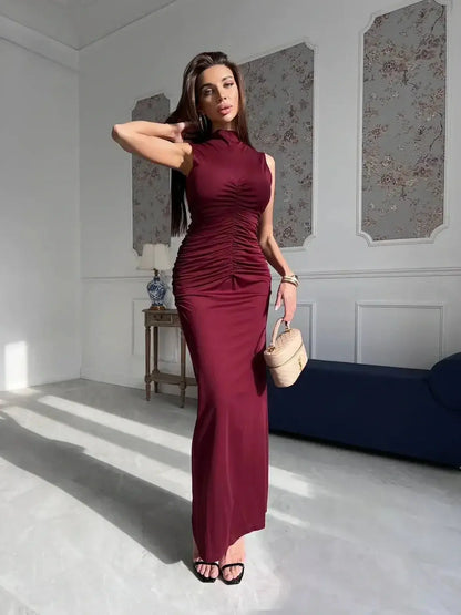 Model showcasing the Silken Rush Maxi Dress in wine red with elegant draping and a sleeveless silhouette.