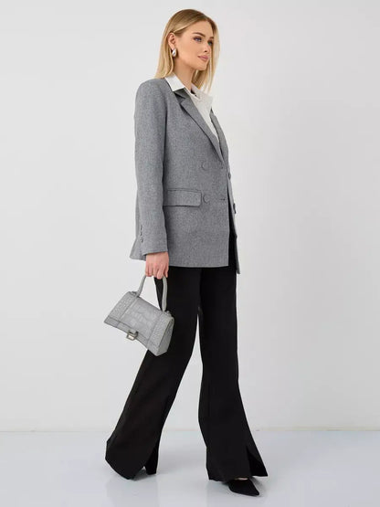 Model showcasing the Silverstone Blazer by Lauven, an oversized double-breasted gray jacket, paired with black pants.