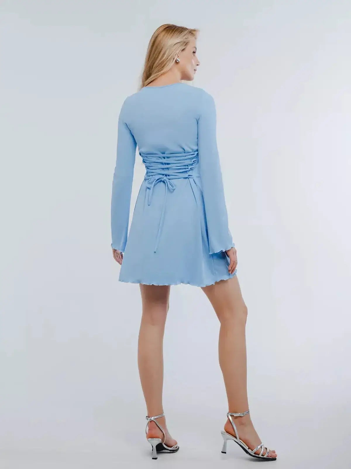 Back view of a baby blue mini dress with long sleeves and lace-up detailing, perfect for summer and wedding guest styling.