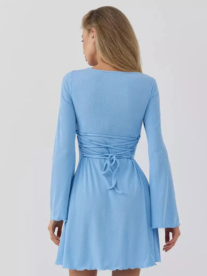 Back view of a woman wearing the Skyline Cutout mini dress by Lauven in sky blue, showcasing its flattering design and chic details.