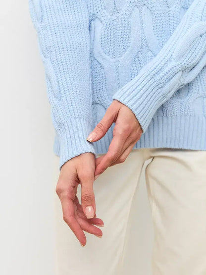 Skyline Knitwear by Lauven, women's oversized pastel blue wool-blend turtleneck sweater with cable-knit pattern.