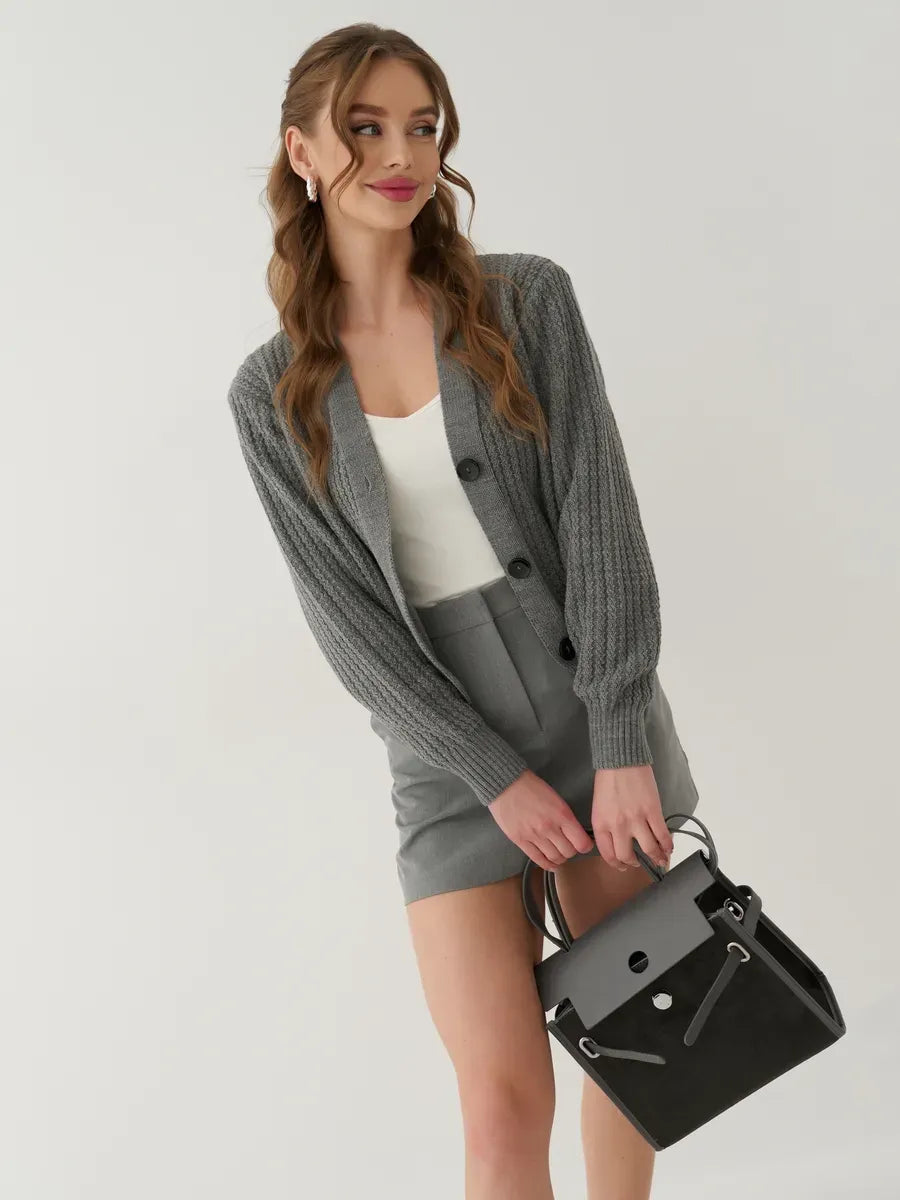 Model wearing the Slate Cardigan by Lauven, oversized cropped knitwear in gray, styled with shorts and a handbag.