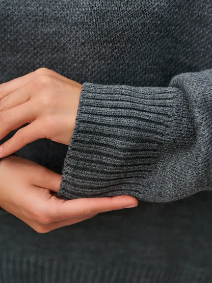 Close-up of hands wearing the Slate Pullover, an oversized cropped women's sweater by Lauven in dark gray.