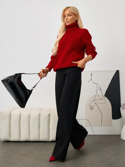 Model wearing the Solara Sweater by Lauven, a cropped oversized knit turtleneck paired with sleek black trousers.