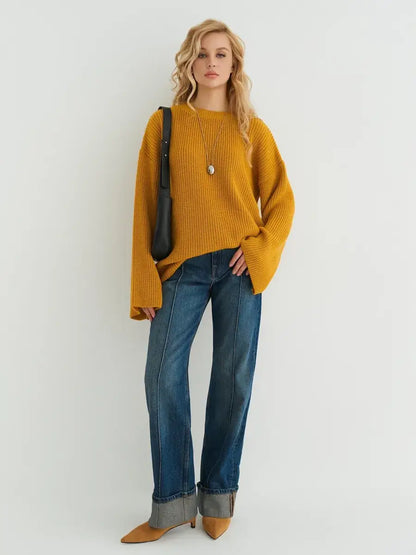Model wearing the Solara Sweater by Lauven in mustard yellow with wide-leg jeans.