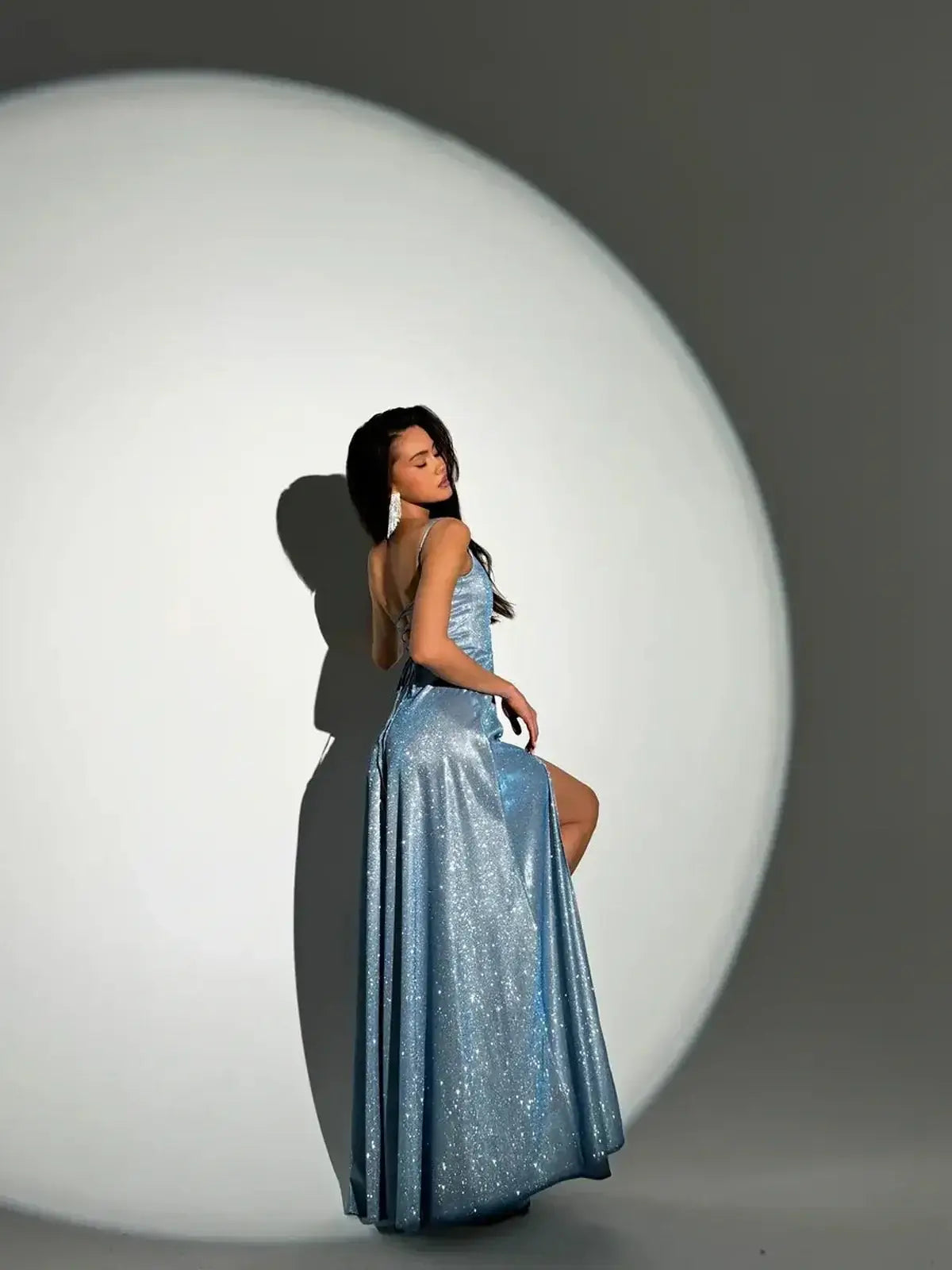 Model showcasing the Starlit Glow Maxi Dress in shimmer-blue with a glittering finish and sultry silhouette.