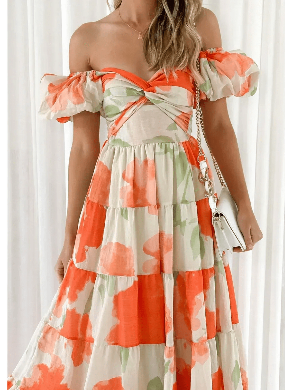 Model wearing the Sunset Bloom Maxi Dress, an off-shoulder design with tiered ruffles and vibrant floral print.