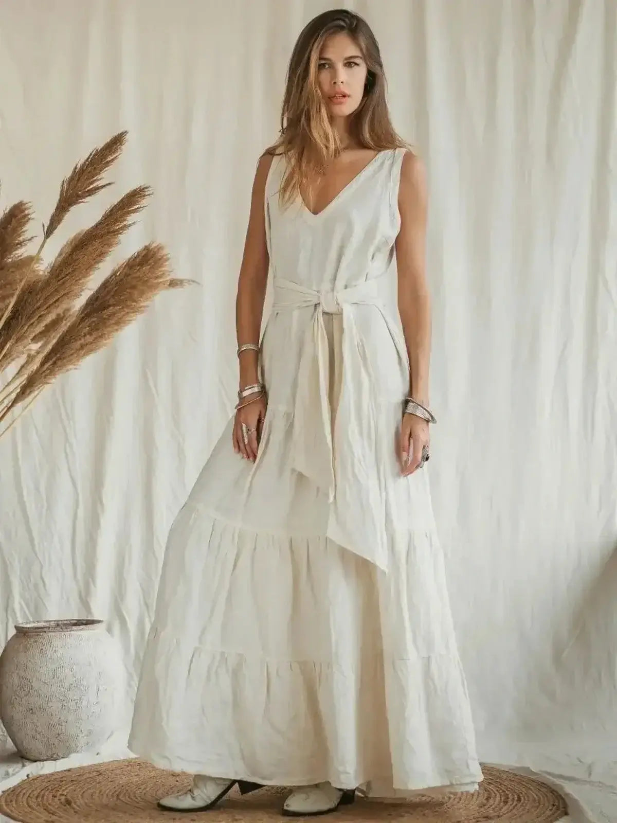 Model showcasing the Suntrace Maxi Dress in lightweight linen, featuring a belted waist and tiered hem on a neutral backdrop.