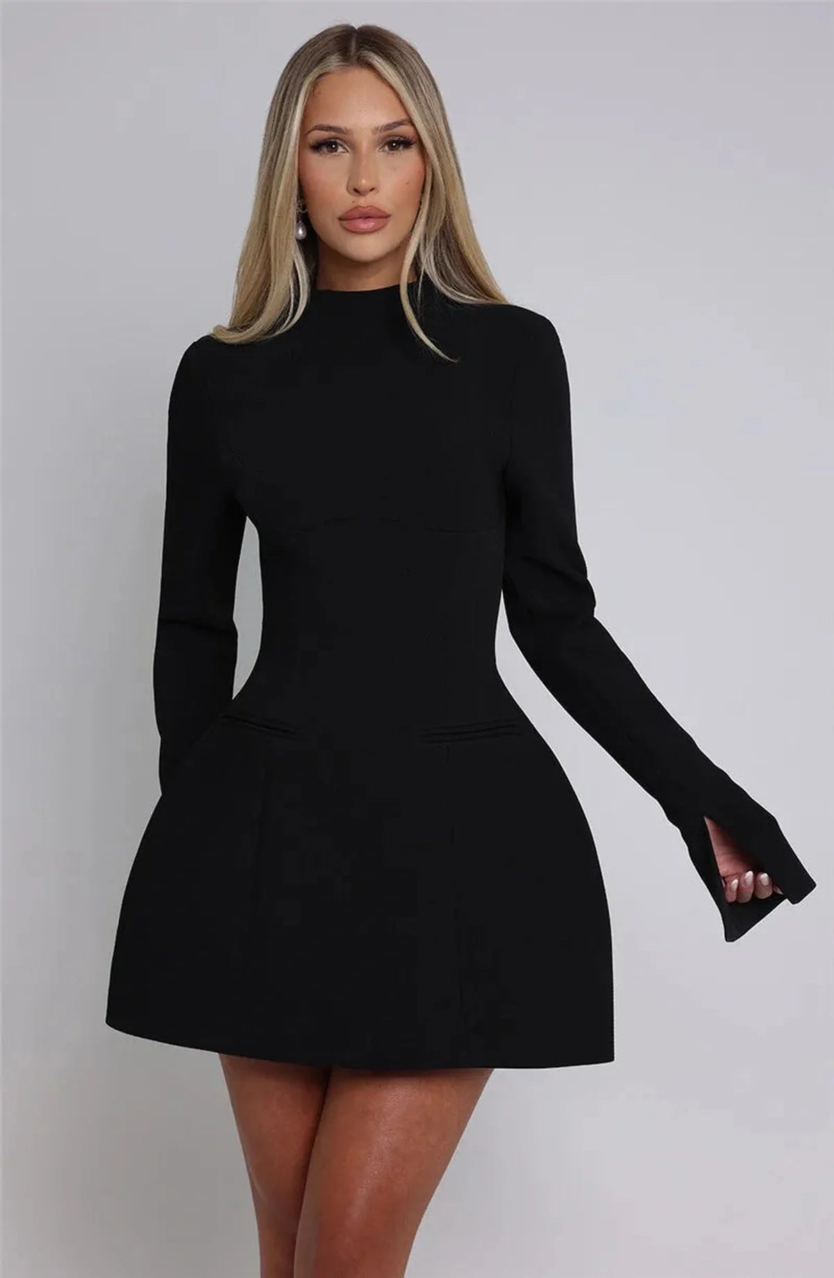 Chic black Tess Mini Dress featuring long sleeves and stylish slit cuffs, perfect for wedding guests or cocktail parties.