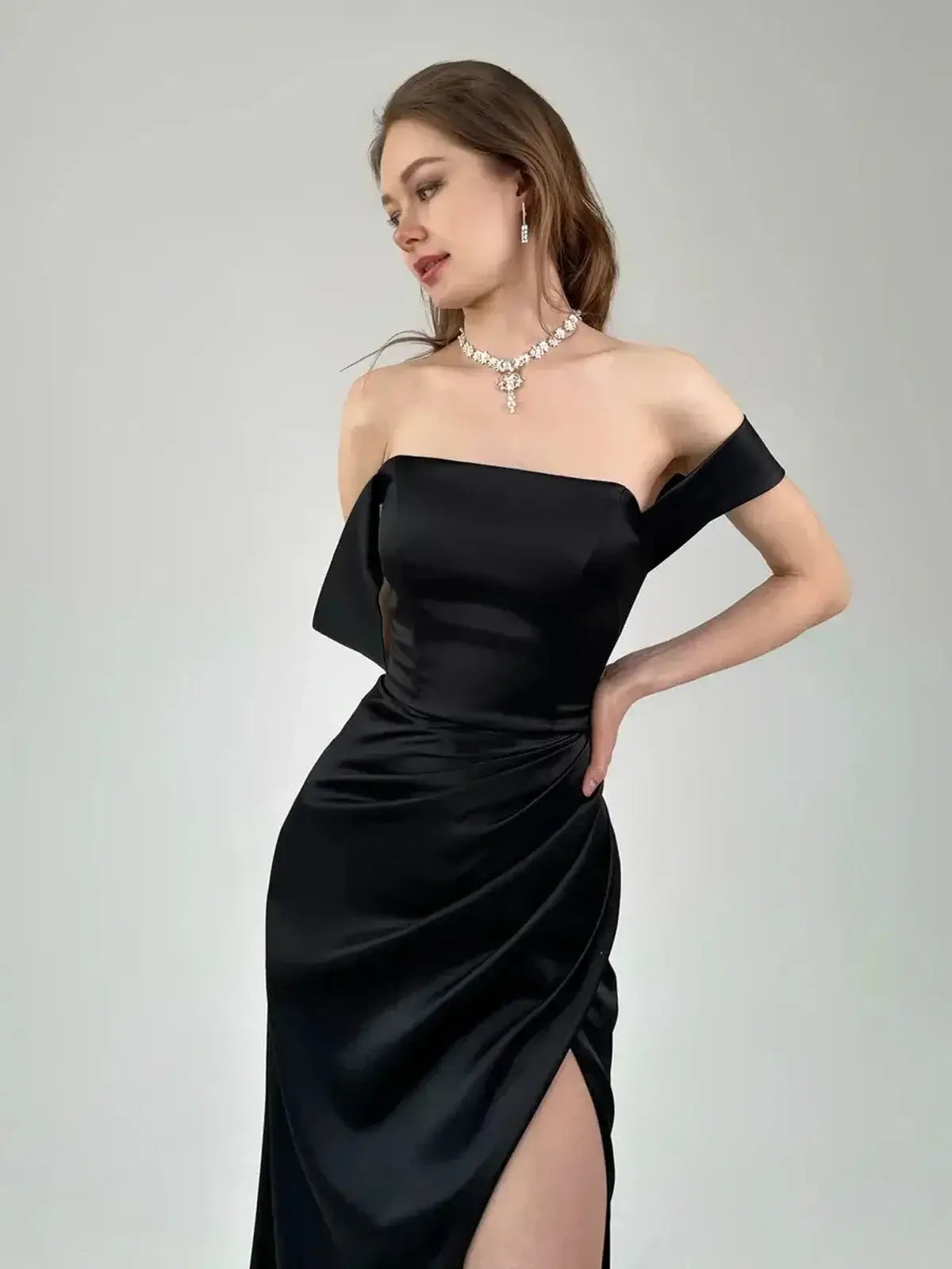 Model showcasing the Velour Nights Maxi Dress with off-shoulder design, elegant draping, and high slit for a sophisticated look.