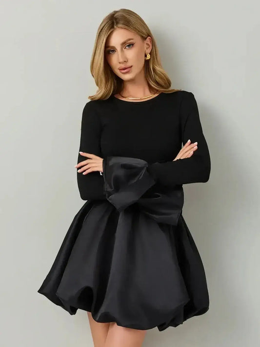 Model wearing Velvet Bloom, a black mini dress with a knit bodice and satin balloon skirt, showcasing modern elegance.