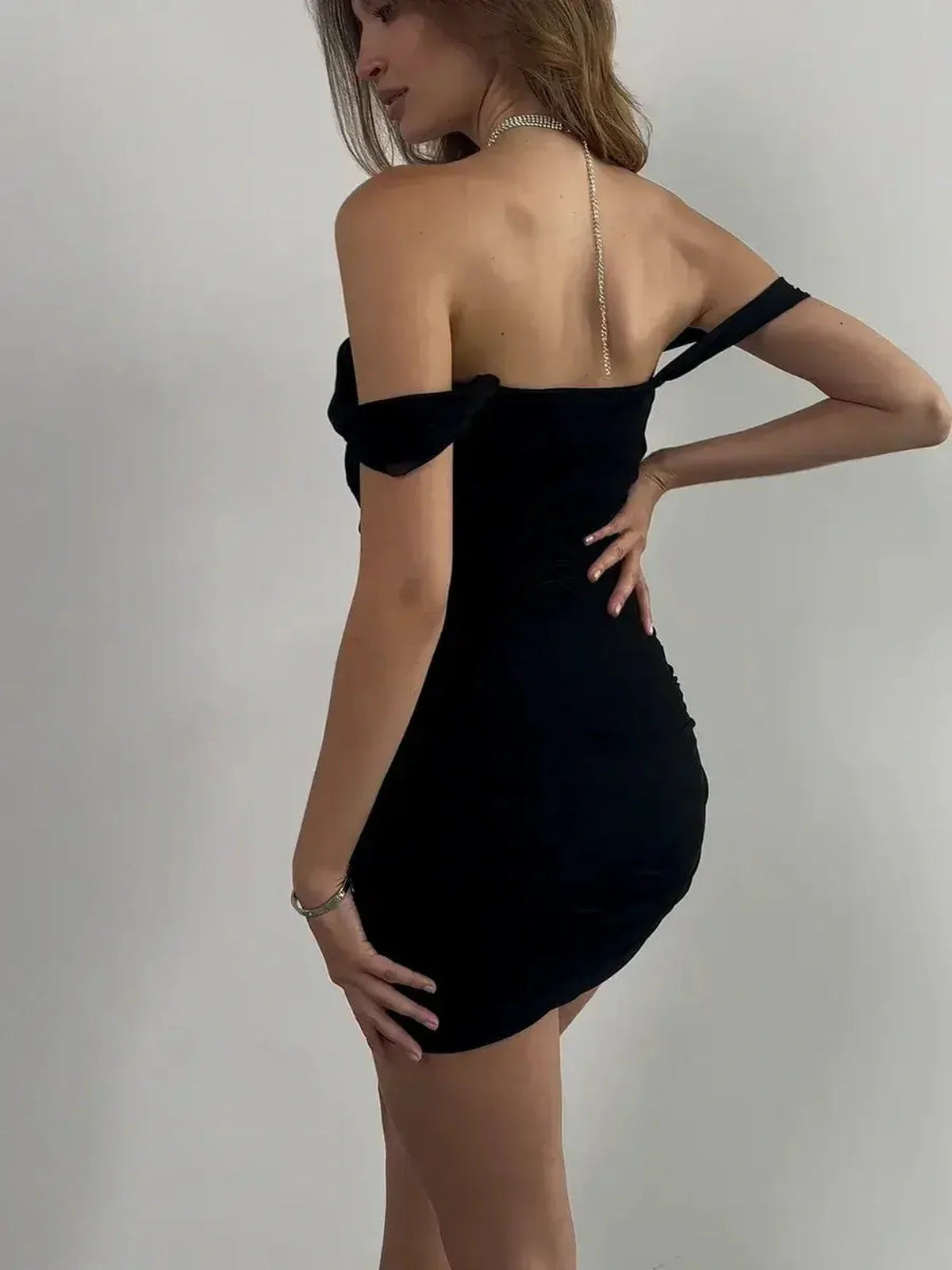 Back view of the Velvet Curve black mini dress featuring an off-shoulder design, perfect for summer nights and formal occasions.