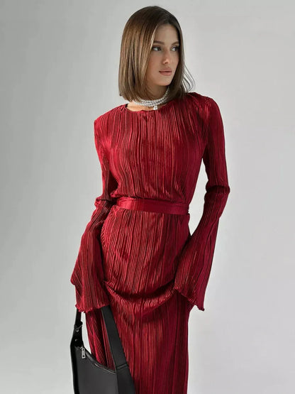 Model wearing the Velvet Flame Maxi Dress with glossy pleats in marsala red and flared sleeves, exuding elegance.