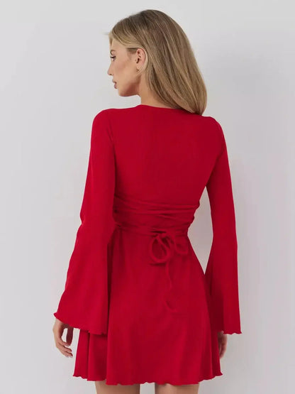 Model showcasing the back of the Velvet Flame red dress by Lauven with a stylish draped hem and fitted bodice.