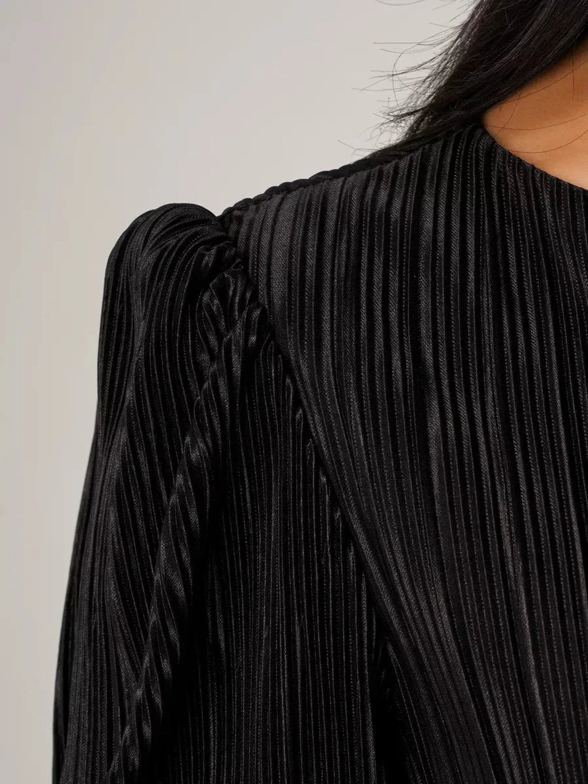 Close-up of Velvet Rhythm Maxi Dress showing its elegant micro-pleated texture and sculptural puff sleeves.