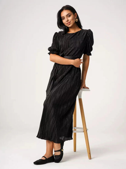 Model wearing Velvet Rhythm Maxi Dress with pleated texture and puff sleeves, showcasing elegance and style.