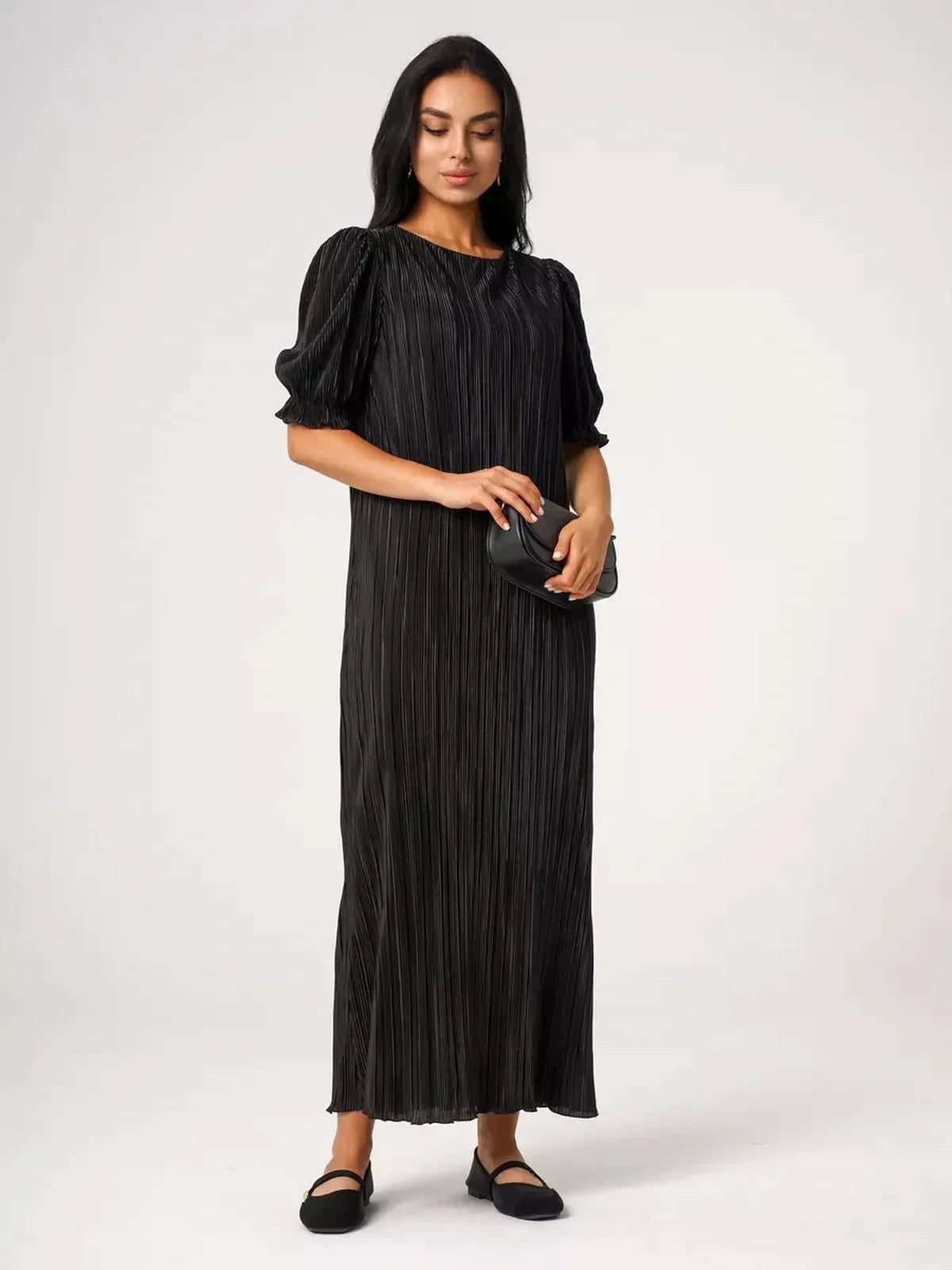 Model wearing the Velvet Rhythm Maxi Dress with pleated design and puff sleeves, exuding elegance and fluid movement.