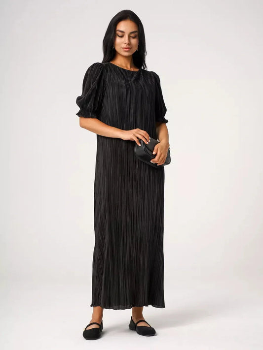Model wearing the Velvet Rhythm Maxi Dress with pleated design and puff sleeves, exuding elegance and fluid movement.