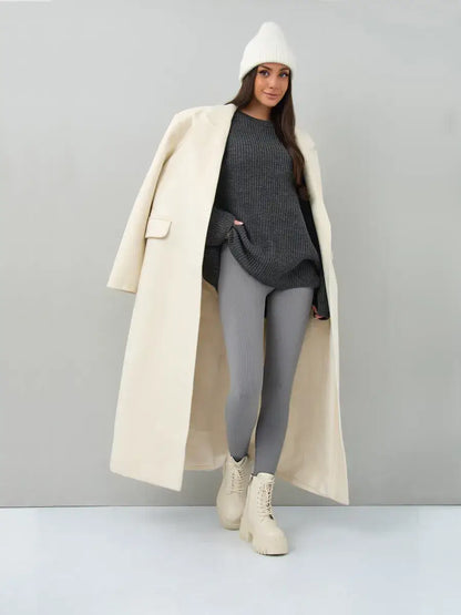 Vera Sweater by Lauven in oversized dark gray knit, paired with leggings and a long cream coat.