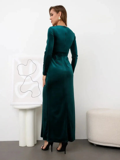 Elegant back view of the Verde Luxe Maxi Dress in emerald green velvet, showcasing its long sleeves and floor-length design.