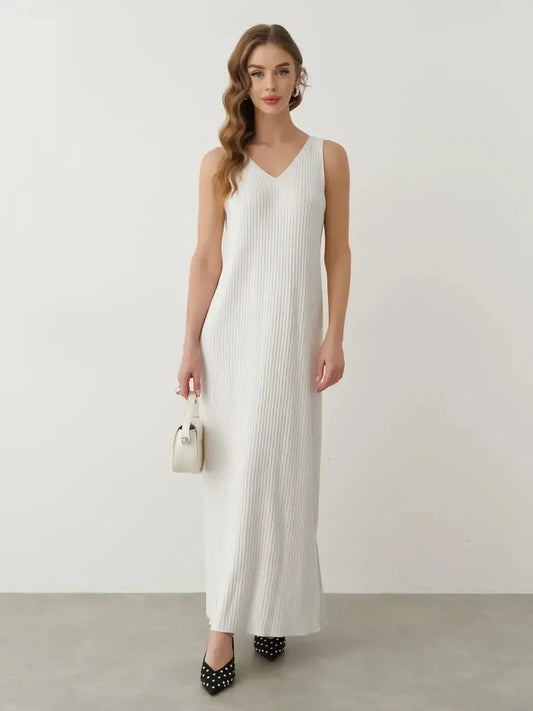 Model wearing the Verona Maxi Dress in white ribbed cotton-acrylic knit, showcasing elegant design and side slit detail.