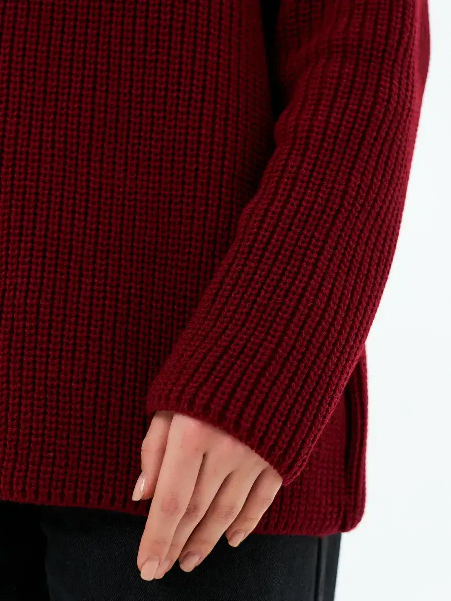 Close-up of the sleeve detail of the Verona Sweater by Lauven in deep burgundy, showcasing its textured knit.