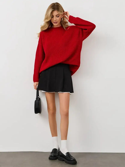 Viona Sweater by Lauven: oversized red knit pullover with crew neck, paired with a black skirt and stylish accessories.