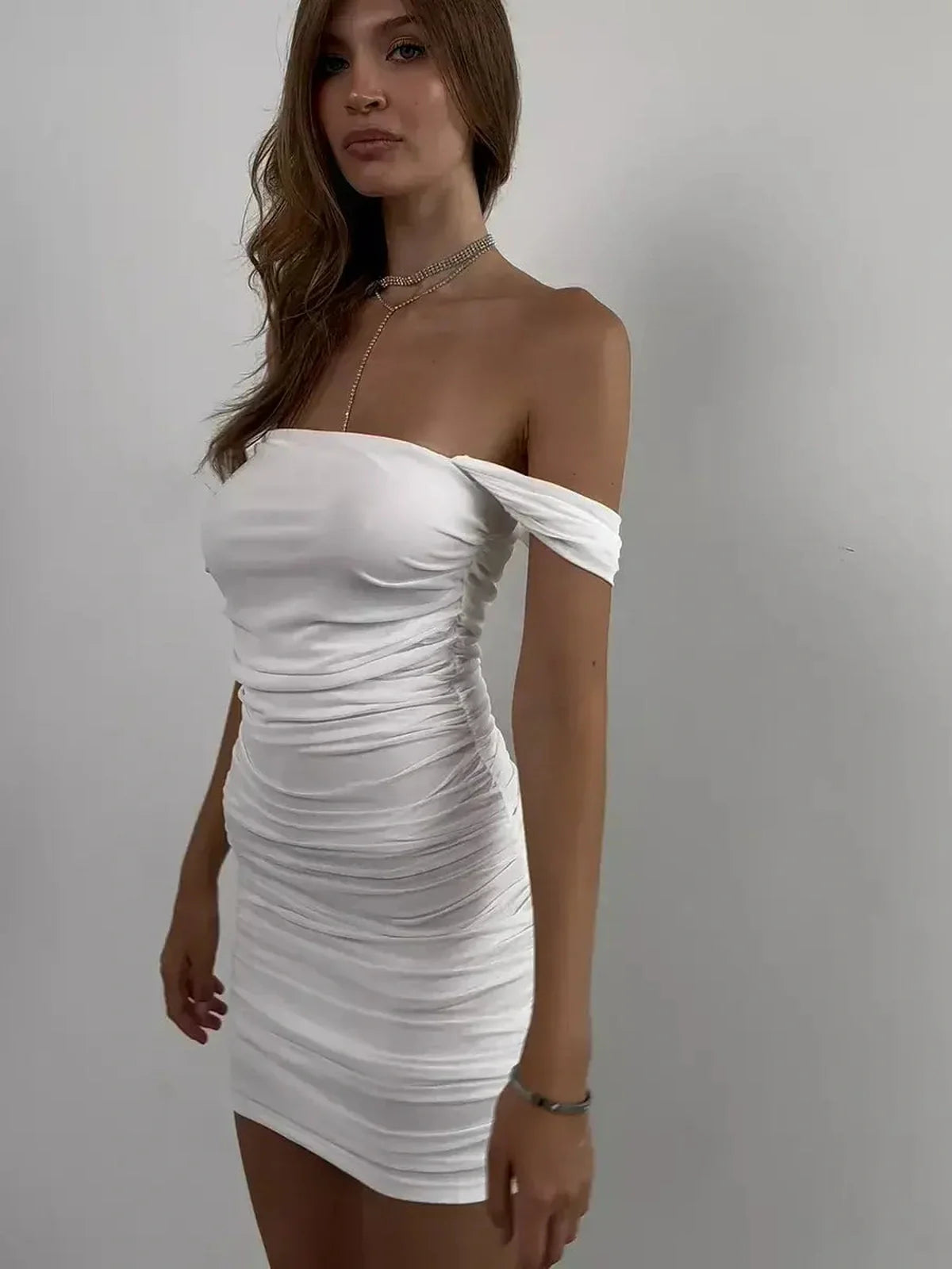 Model wearing a white off-shoulder mini dress with ruching, ideal for weddings, proms, and summer celebrations.