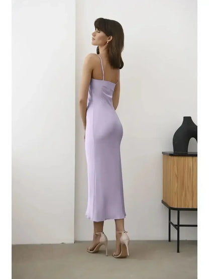 Back view of a model wearing the Whisper Midi Dress in soft lavender, showcasing its sleek satin drape.