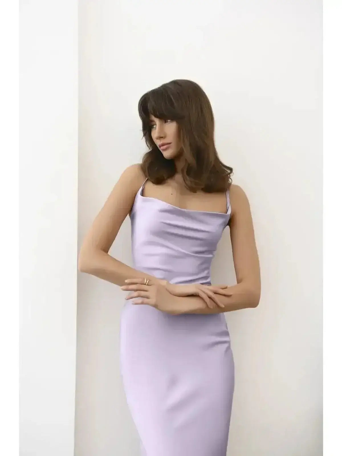Elegant model wearing a sleek lavender satin Whisper Midi Dress with a draped neckline.