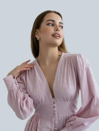 Model wearing the Willow Grace Maxi Dress, showcasing its elegant pink fabric and plunging neckline.