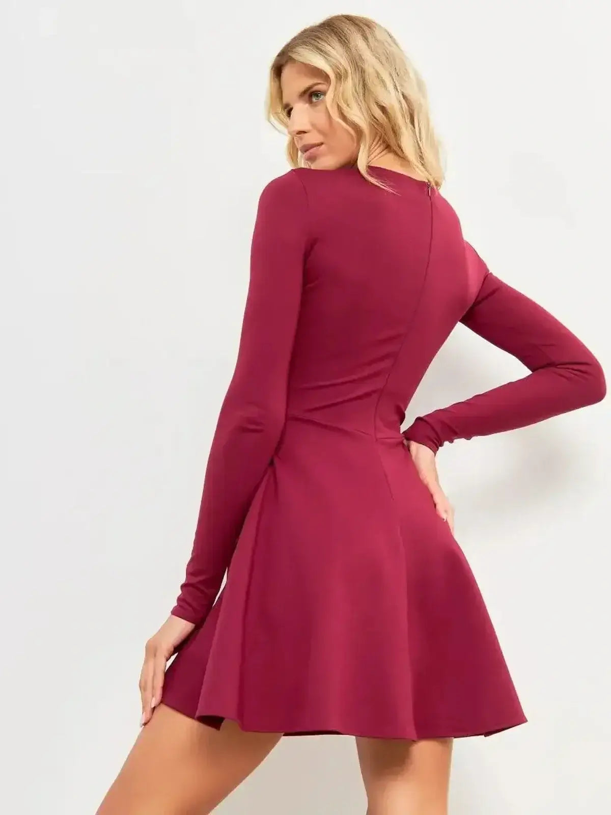 Back view of a woman in a Wine Flare Mini dress with long sleeves and a flared hem, showcasing its elegant design.