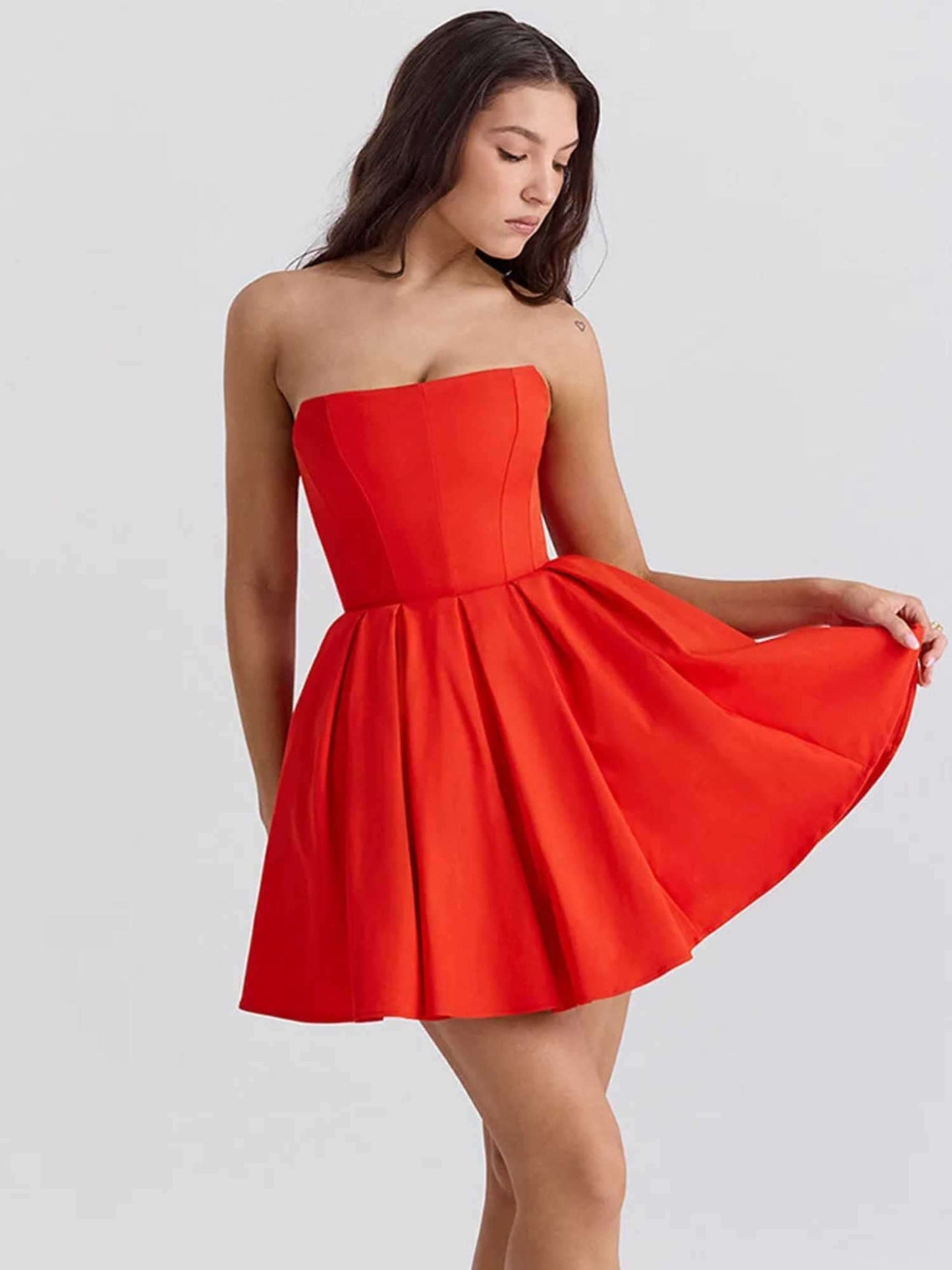 Bright red mini dress with a strapless, corset-inspired bodice and voluminous skirt, perfect for summer parties.